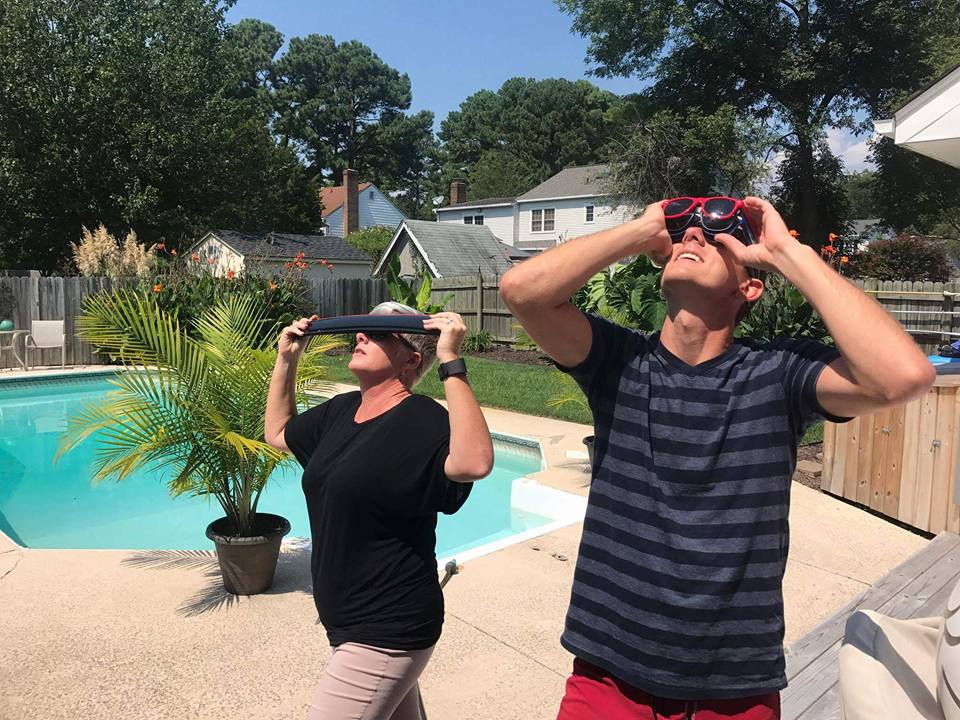 Two people standing in a yard looking at something