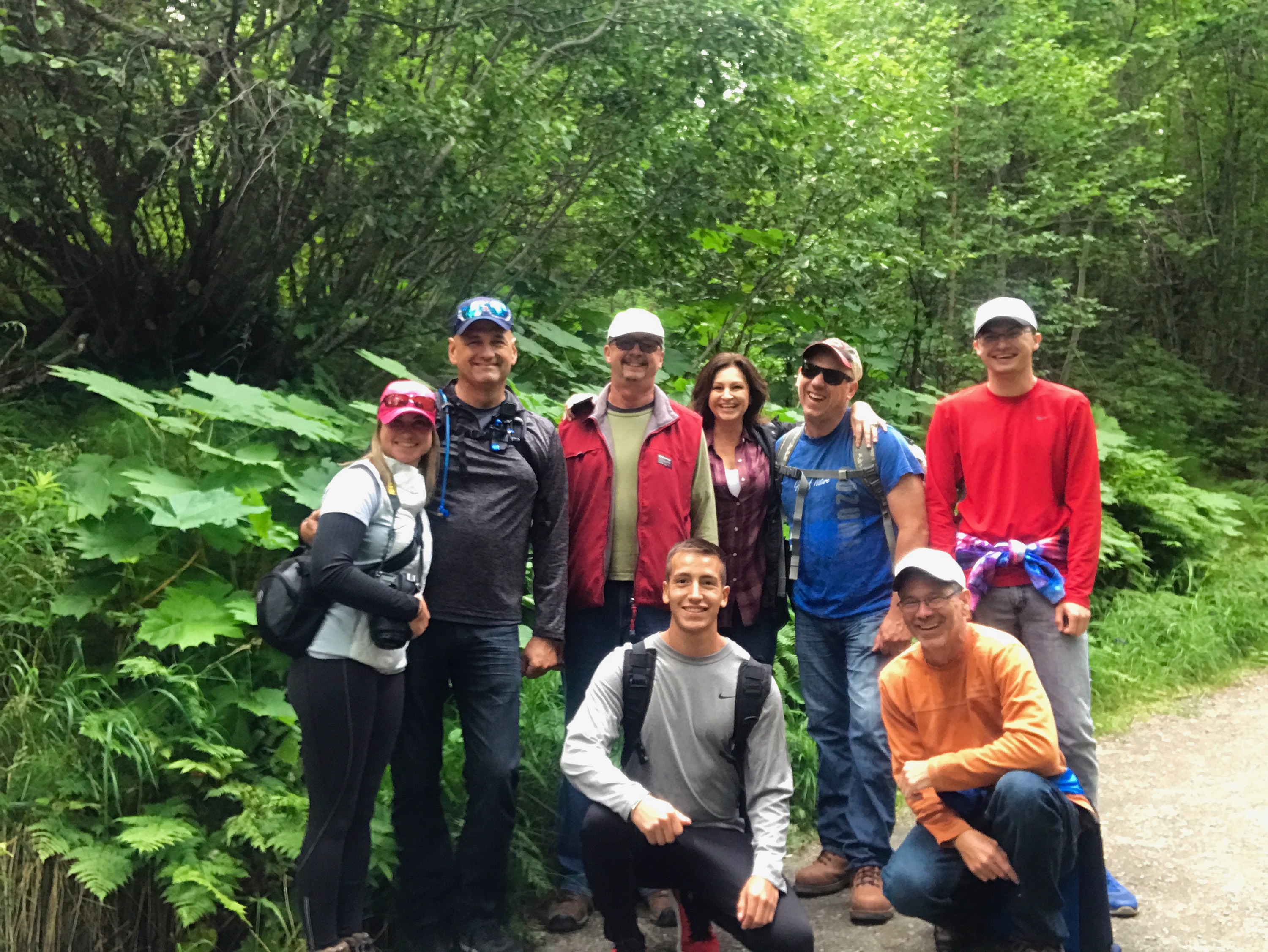 A group of people standing in front of some trees